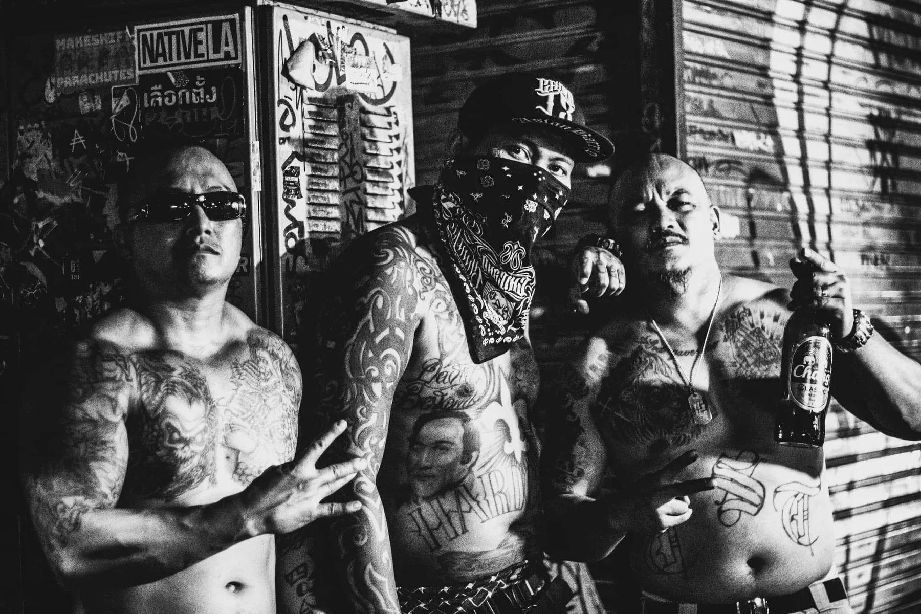 Four tattooed friends standing together in a Bangkok alley