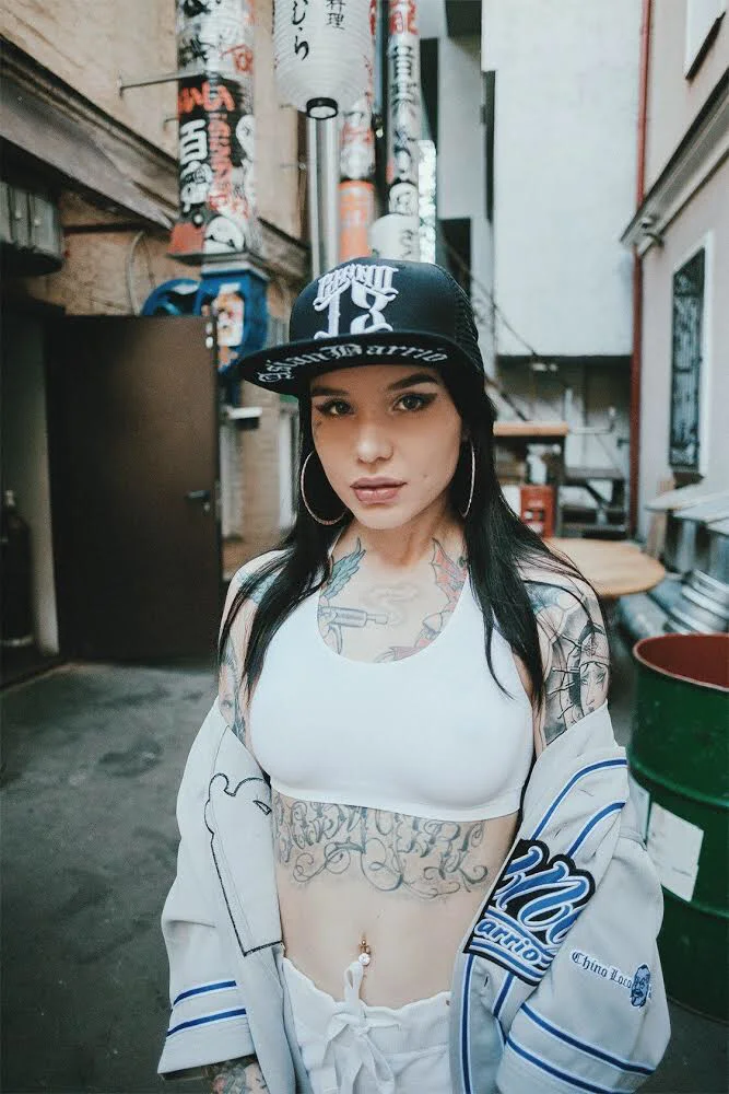 Tattooed model wearing an Asian Barrio cap and baseball jersey