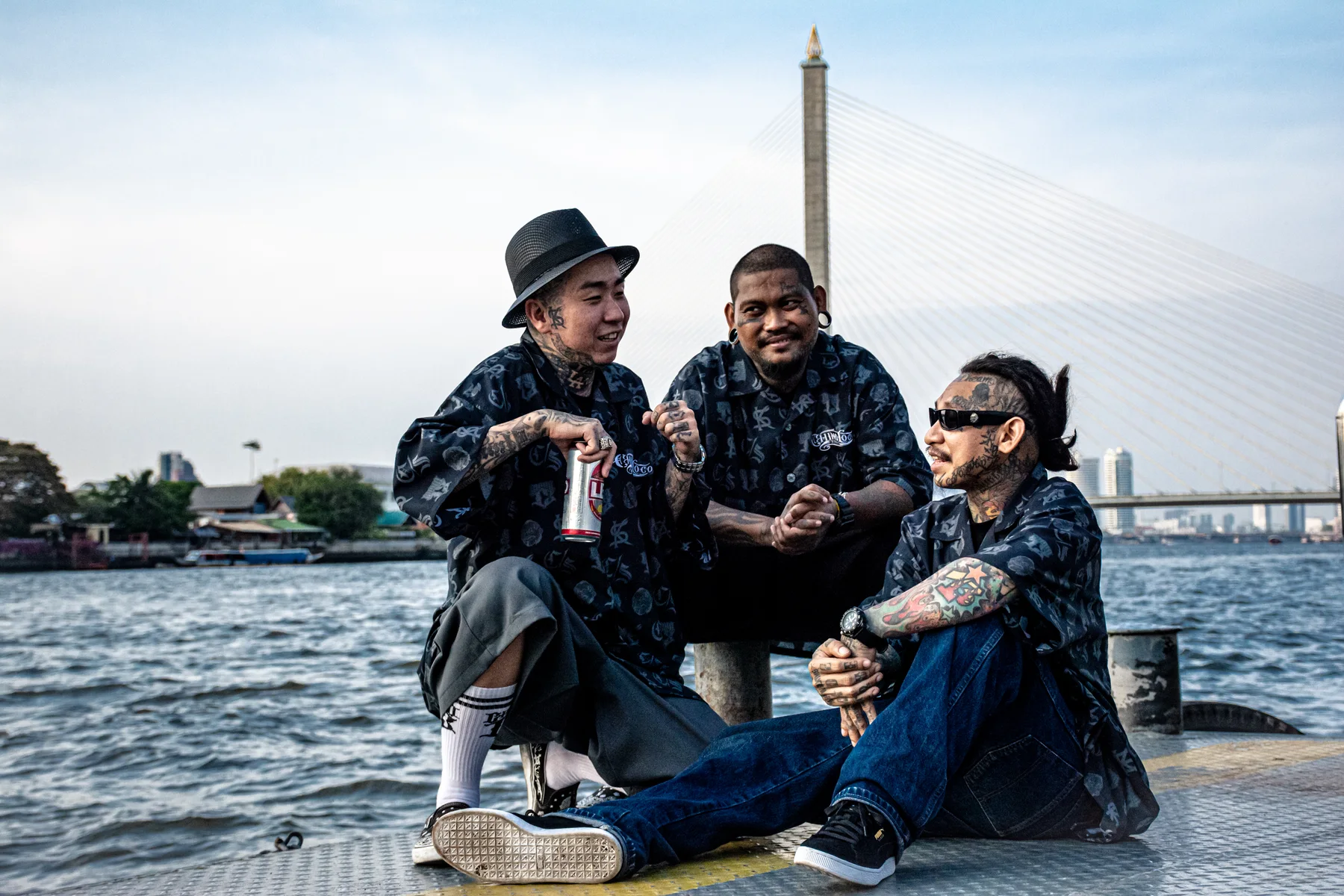 Three friends together beside the Bangkok river