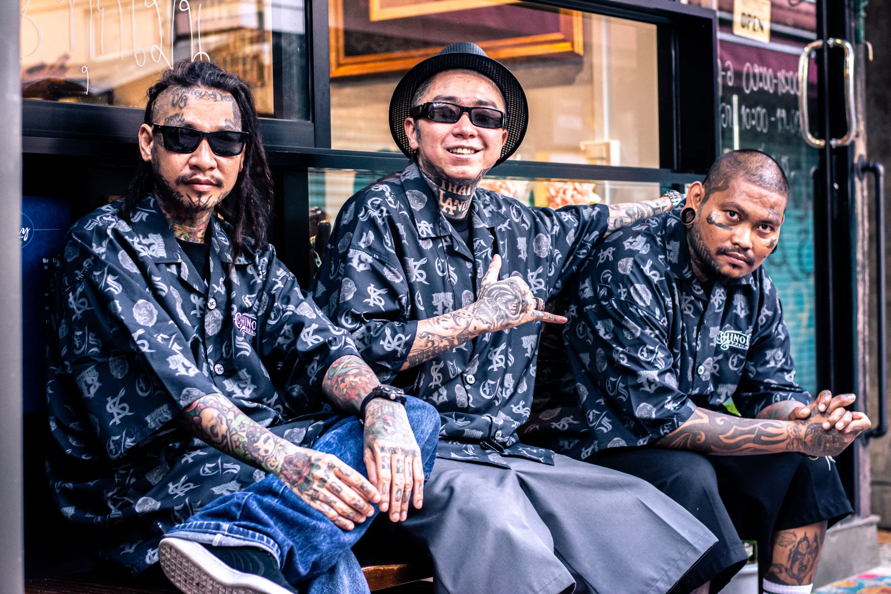 Three Asian Barrio brothers seated together on the street